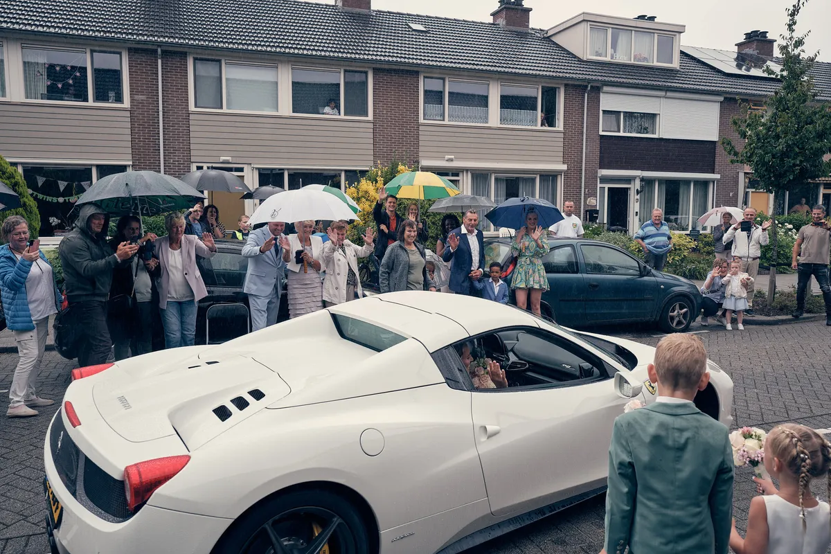 De Ferrari in de straat, hun zoon kijkt mee