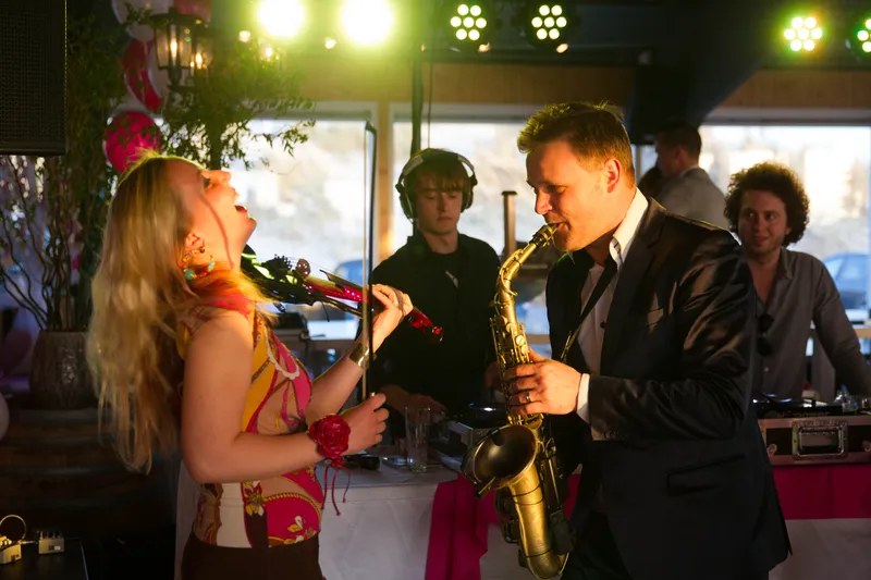 Een zangeres en een saxofonist op het feest