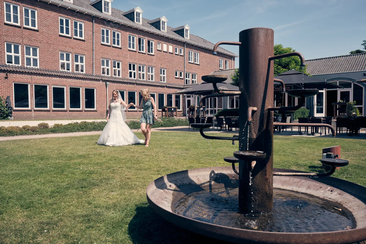 Ilja loopt in de verte door de tuin van het hotel, langs de ronde fontein