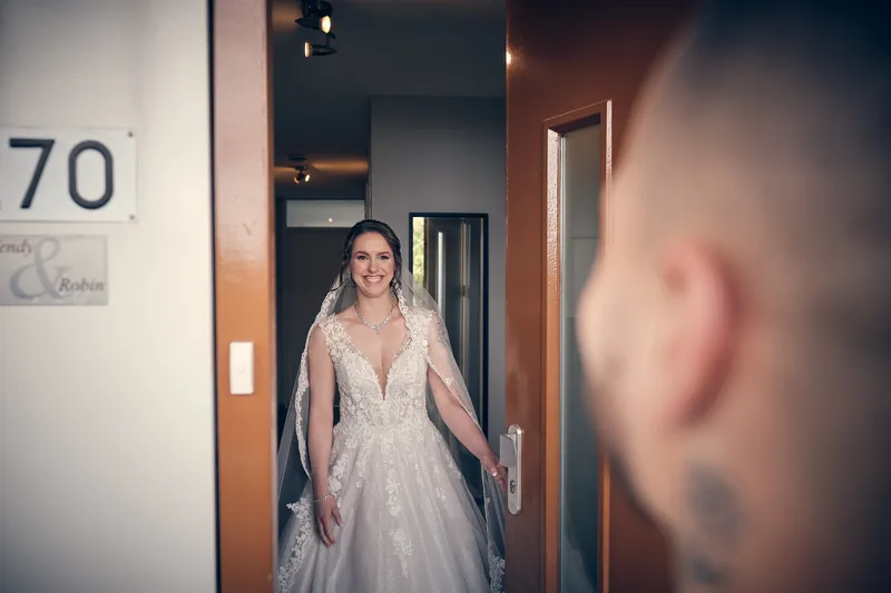 Wendy komt in haar trouwjurk de deur uit, Robin wacht op de voorgrond