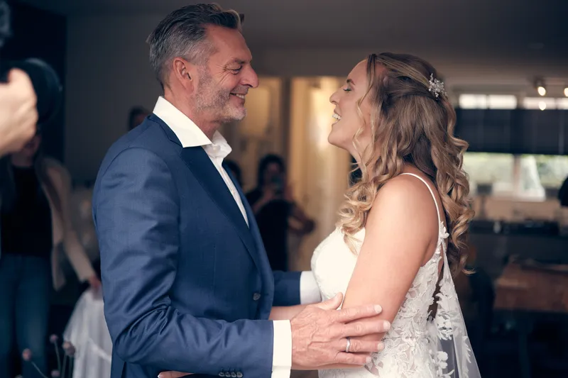 Kim en haar vader kijken elkaar lachend aan