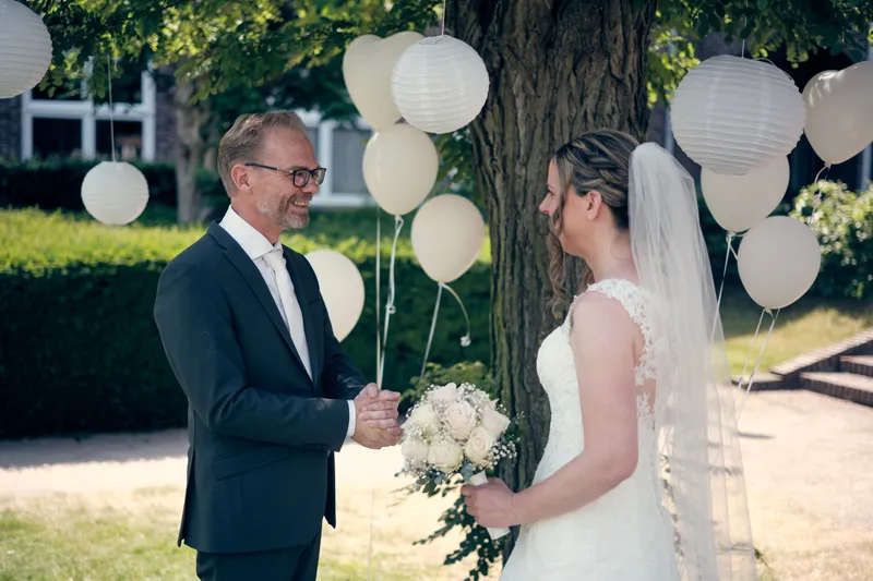 Mike en Ilja hand in hand onder de boom met witte lampionnen