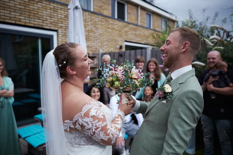 Liëla en Jeffrey lachen naar elkaar bij de tuindeur