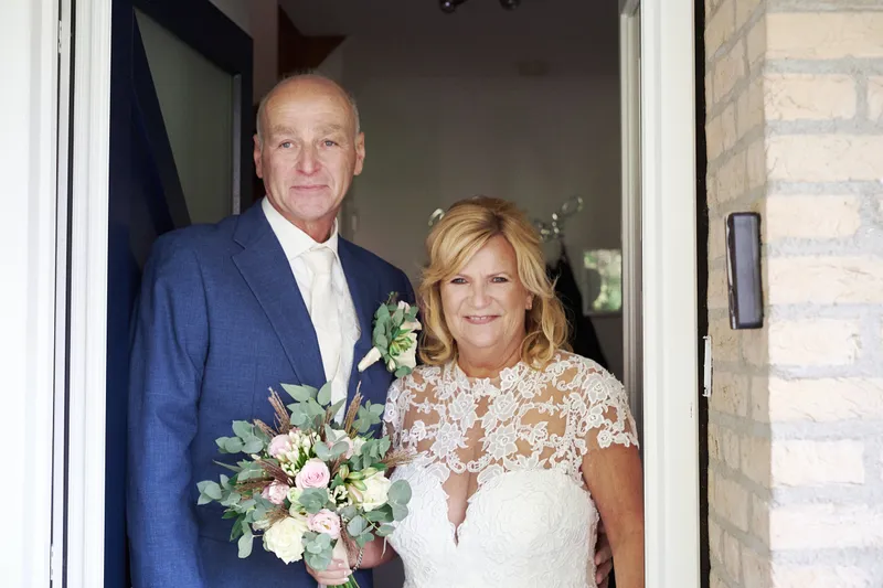 Cees en Jopie samen in de deuropening, met het boeket