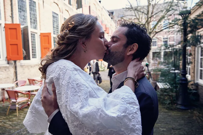 Anouk en Raphaël kussen elkaar bij het terras van het hotel