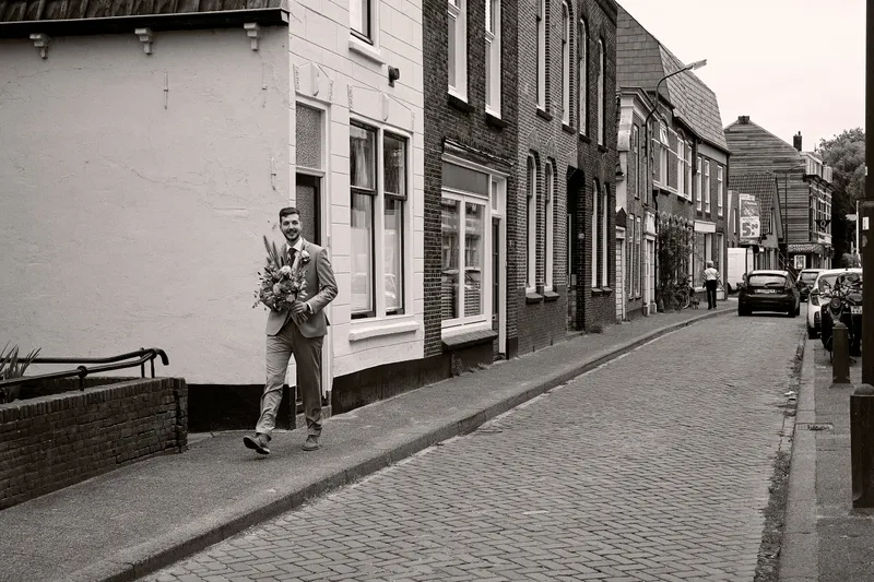 Thèron loopt met zijn boeket door een straatje in Woerden