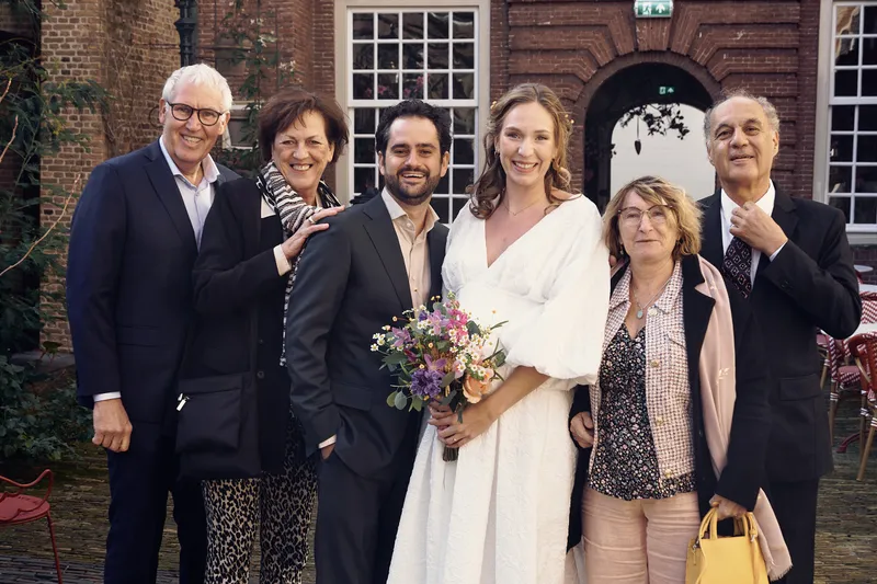 Anouk en Raphaël met hun ouders voor de gevel van het hotel