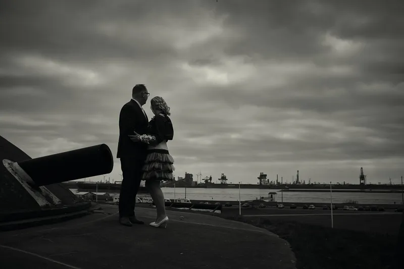 Sander en Maud kussen bij het kanon van Fort 1881, met de haven op de achtergrond