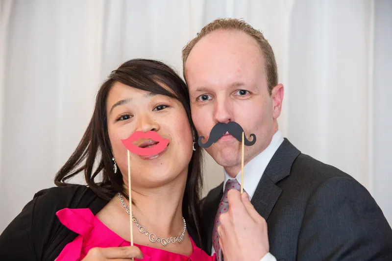Twee gasten met snor en lippen in de fotobooth