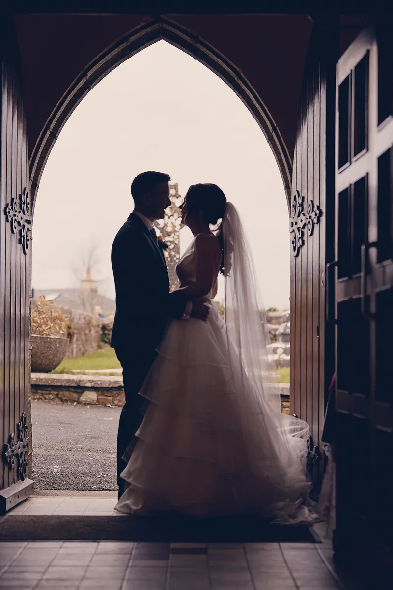 Shane en Caitriona als silhouet in de stenen kerkdeur