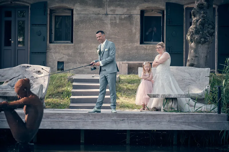 Angelique en Michiel op de steiger aan het water, hun dochter kijkt toe