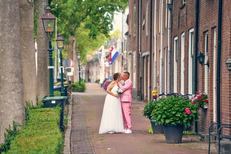 Diliana en Olav kussen elkaar in een straatje met lindebomen en geveltjes