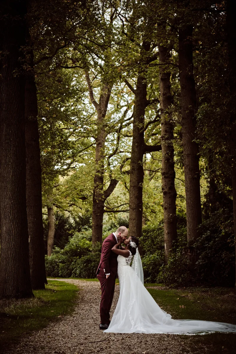 Natascha en Tim kussen elkaar tussen de hoge bomen