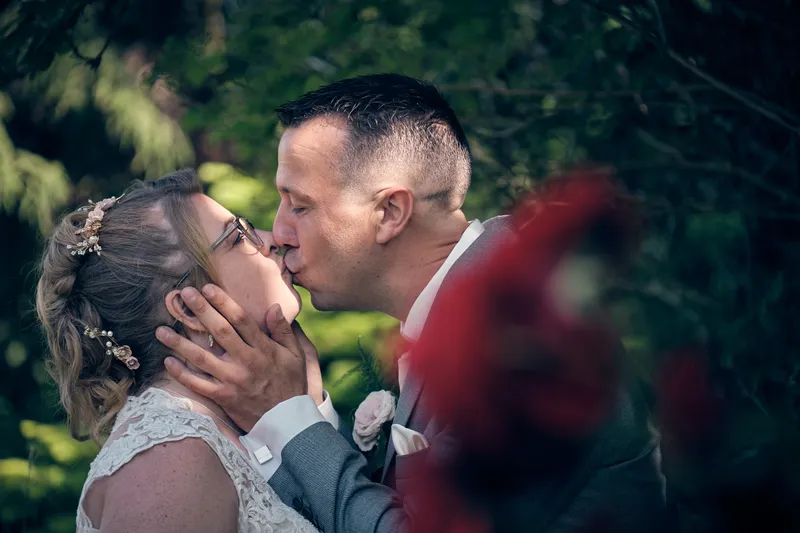 Michiel kust Angelique, met een rode roos op de voorgrond