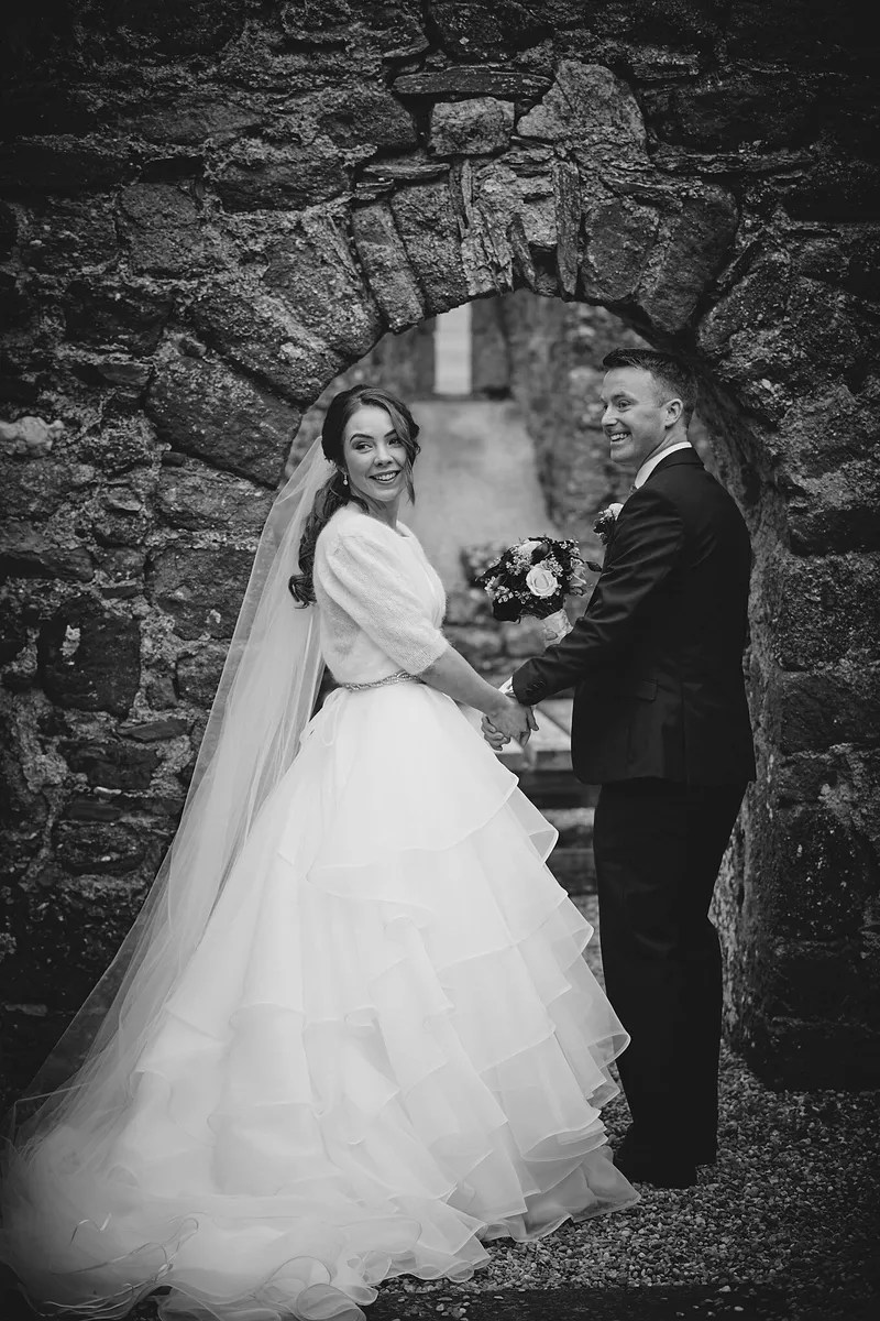 Caitriona en Shane in een stenen boog van de ruïne, in zwart-wit