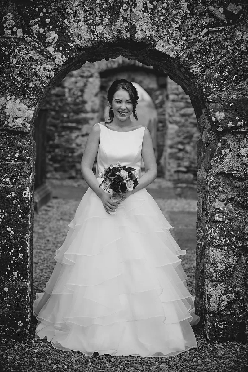 Caitriona in een stenen boog van de ruïne, in zwart-wit
