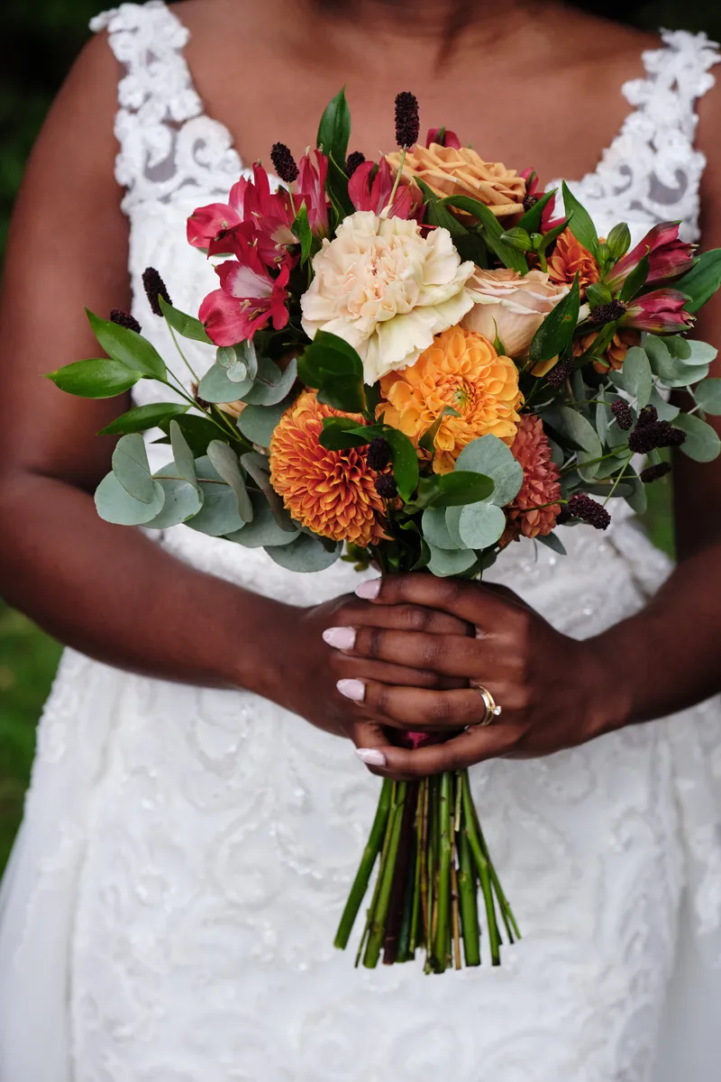 Het herfstboeket van Natascha met oranje en rode bloemen