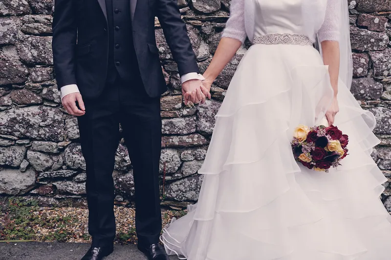 Shane en Caitriona hand in hand voor de stenen muur