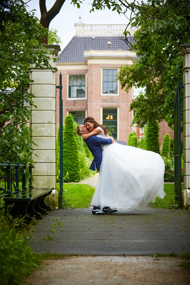 Wouter tilt Rinkje op bij het hek, met het huis erachter
