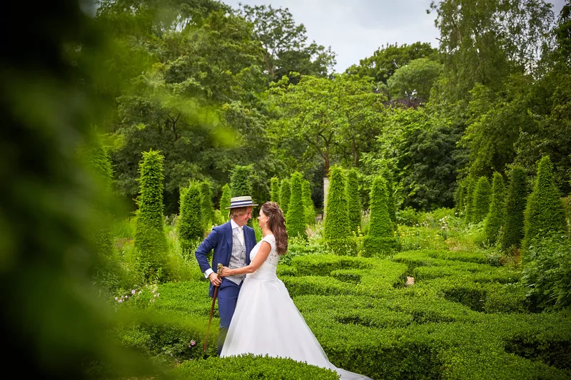 Rinkje en Wouter tussen de geschoren hagen in de tuin