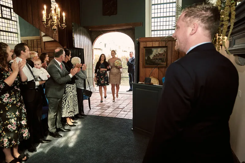 De gasten wachten bij de entree van de trouwzaal