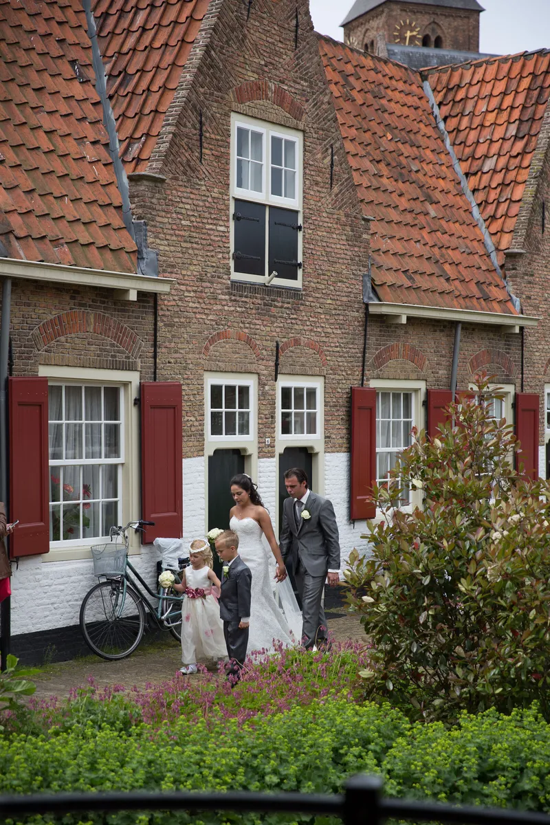 De huisjes met rode luiken in het Heilige Geesthofje, met gasten bij de ingang