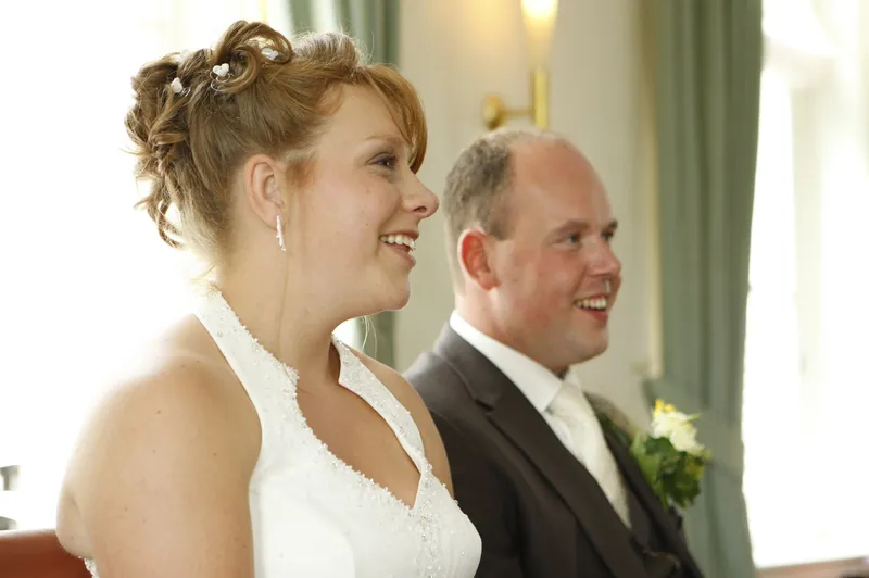 Yvonne en Robert-Jan zitten lachend naast elkaar tijdens de ceremonie