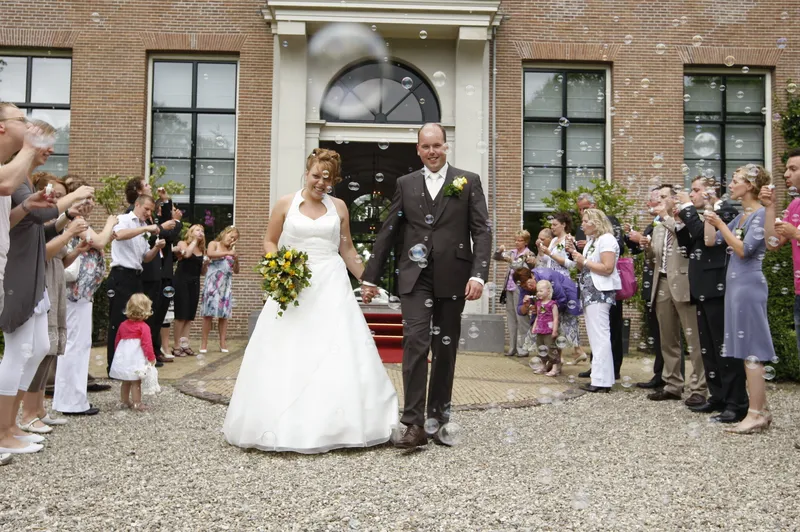 Yvonne en Robert-Jan lopen door de bellen naar de tuin van het gemeentehuis