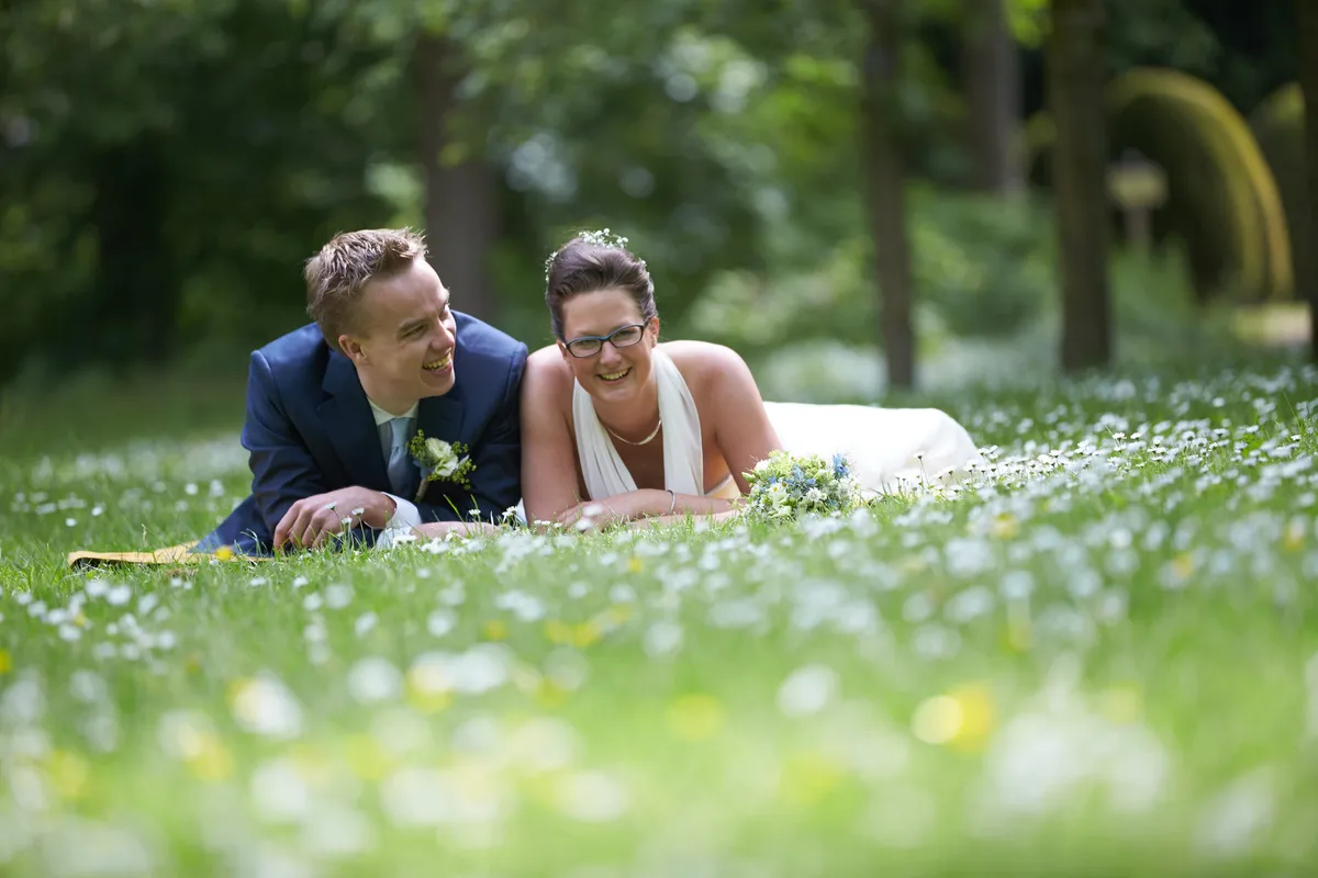 Marjolein en Coen liggen samen in het gras vol madeliefjes