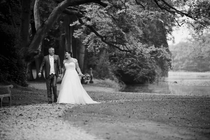 Zwart-wit: Jessica en Eric lopen over een lange laan tussen de bomen
