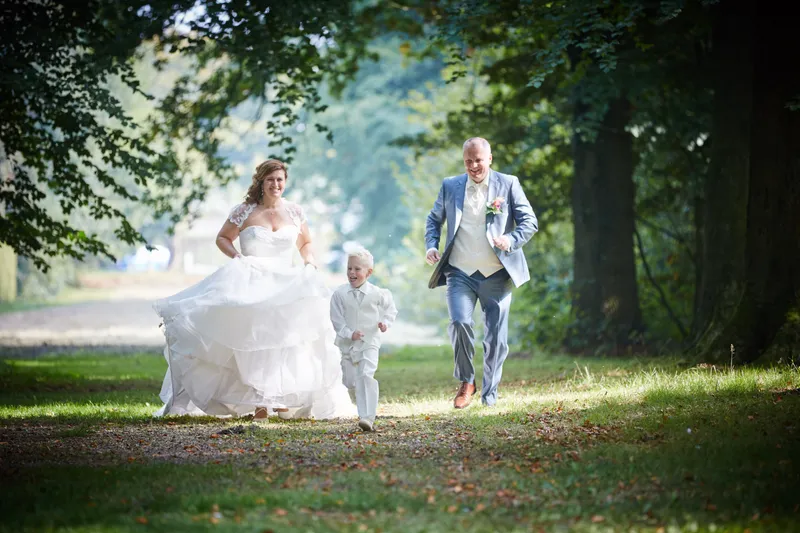 Jessica rent over het gras, Eric en hun zoontje volgen