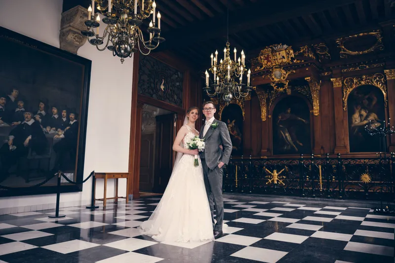 Yvo en Marjolijn op de zwart-witte vloer voor een groot schilderij