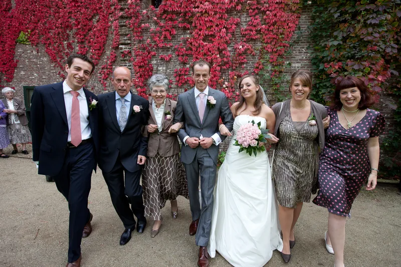 Jorinda en Gerben lopen met familie langs de rode klimop van het kasteel