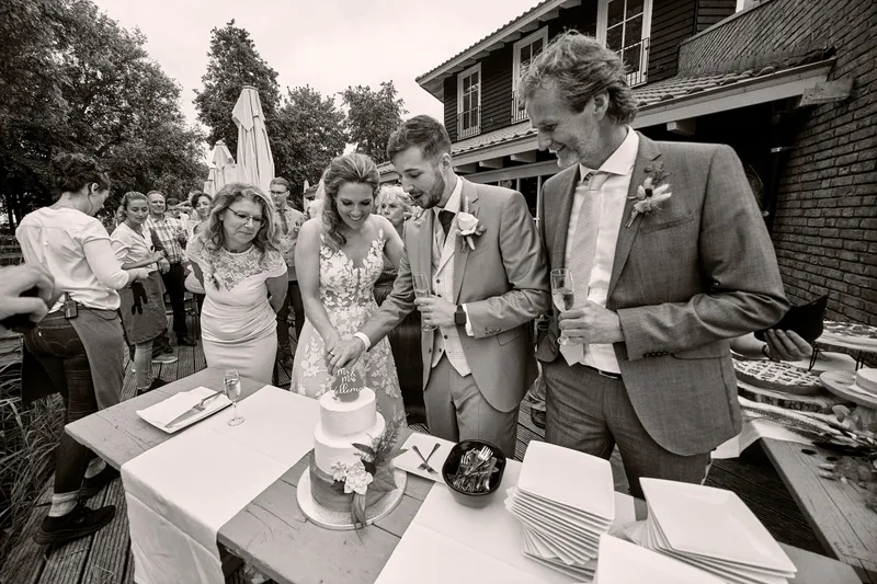 Milou en Thèron snijden de taart aan op het terras