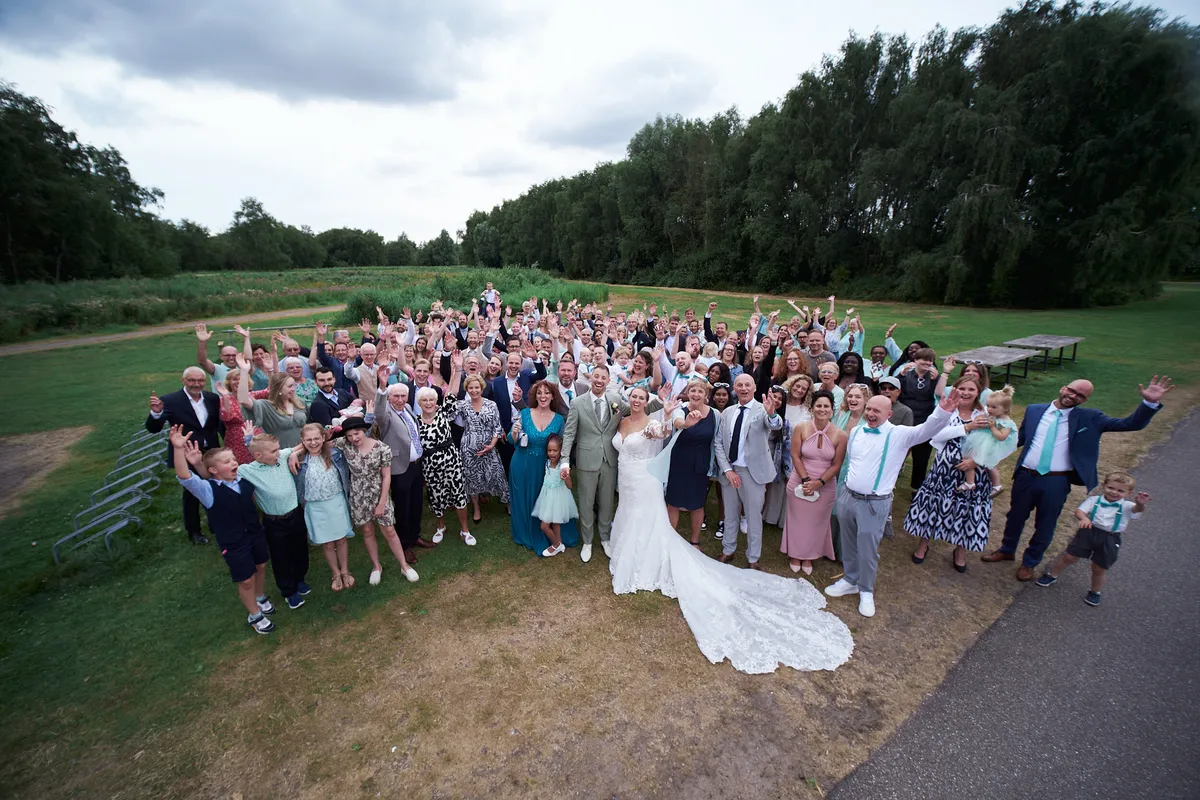 De groepsfoto met alle gasten op het gras