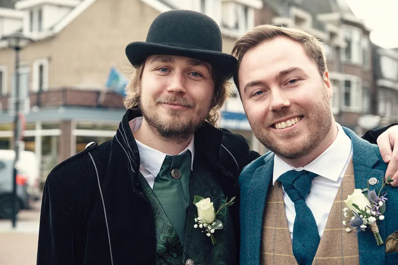 Een bruidegom met een vriend met bolhoed