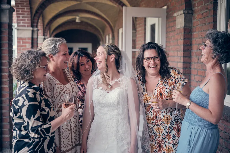 Ilja lacht in het hotel tussen een groep vrouwen