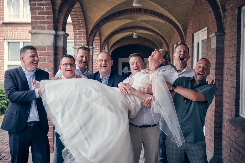 De mannen tillen Ilja in haar trouwjurk op in de gewelfde gang van het hotel