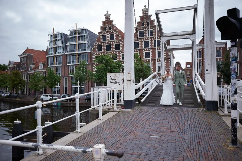 Liëla en Jeffrey lopen over de witte Gravestenenbrug, met de oude gevels erachter