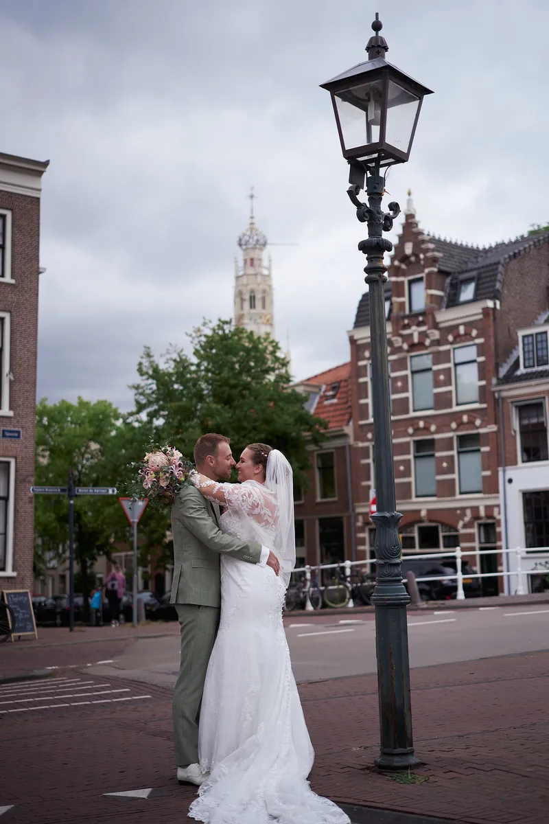 Liëla en Jeffrey onder een straatlantaarn, met de toren van de Grote Kerk in de verte