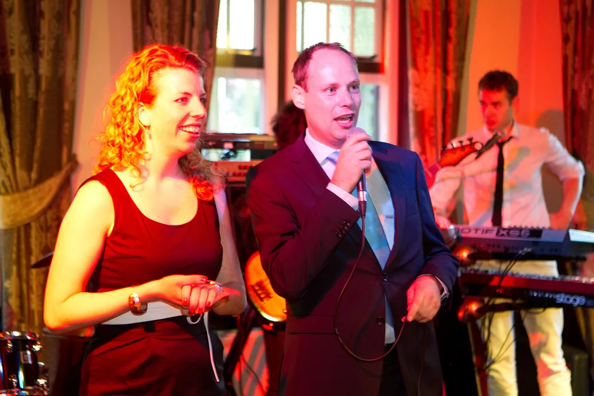 De zangeres en de toetsenist van de band in rood licht