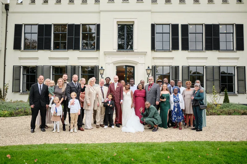 De groepsfoto van alle gasten voor de witte gevel van Huis de Salentein