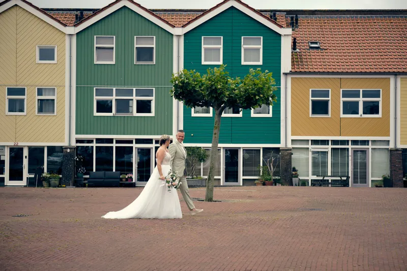 Marco en Tamara voor de gekleurde houten huizen aan de haven van Hellevoetsluis