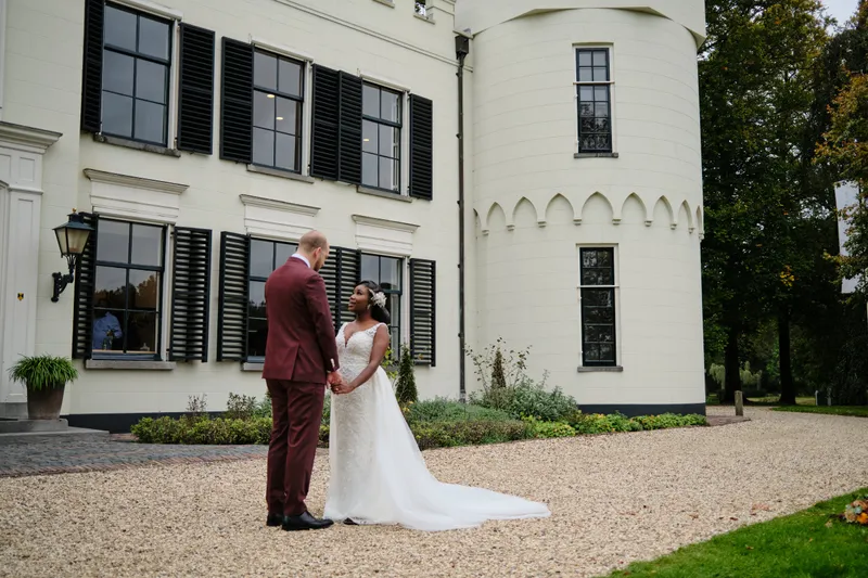 Natascha en Tim staan hand in hand voor het witte Huis de Salentein met zijn torentje