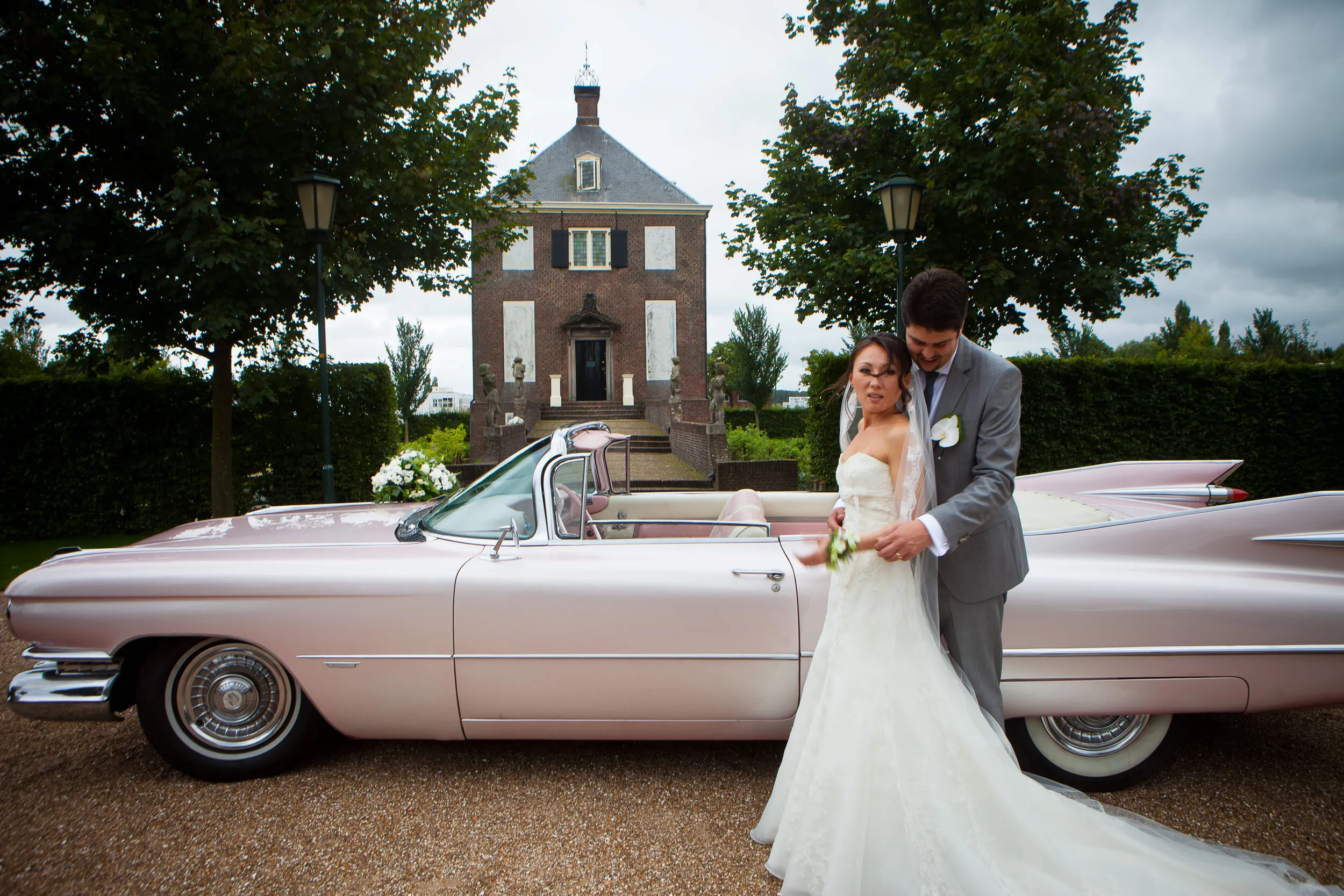 Ivan en Roza bij de roze Cadillac, met Hofwijck in Voorburg op de achtergrond