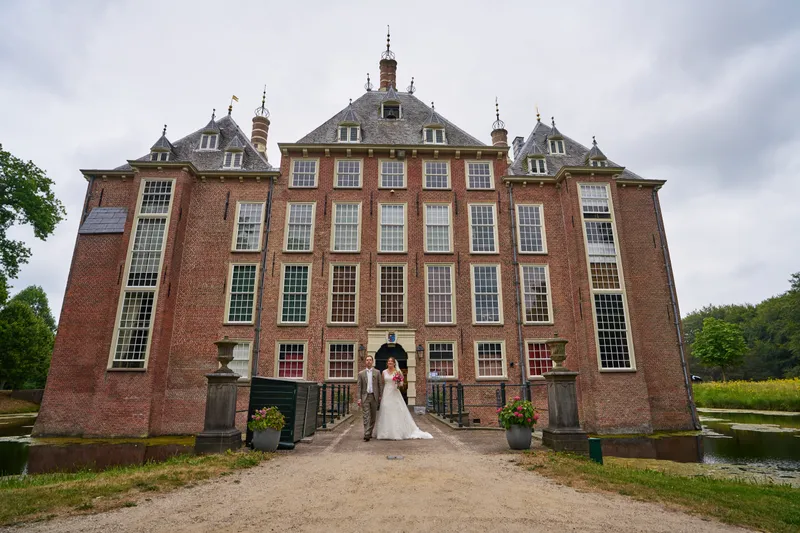 Rutger en Caroline staan klein voor de voorgevel van Kasteel Duivenvoorde