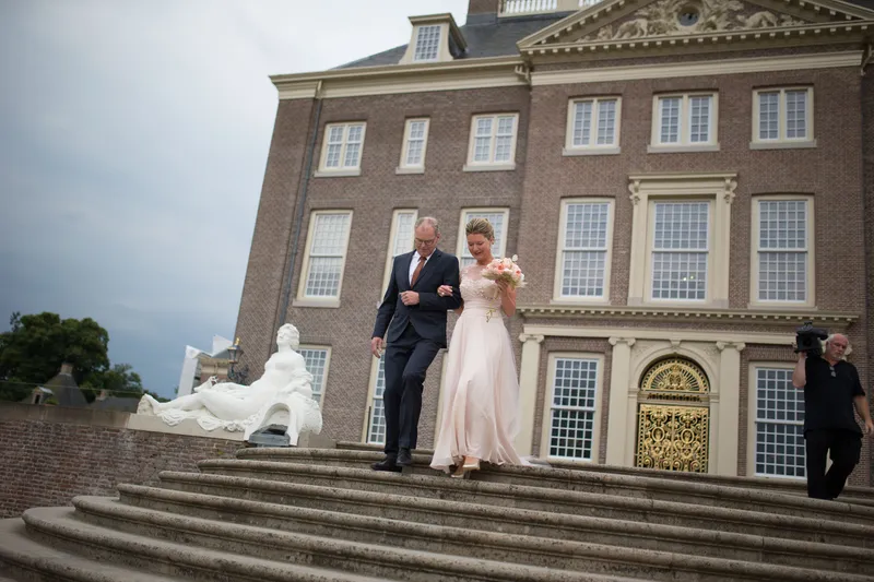 Jaqueline loopt over het bordes met de stenen leeuwen