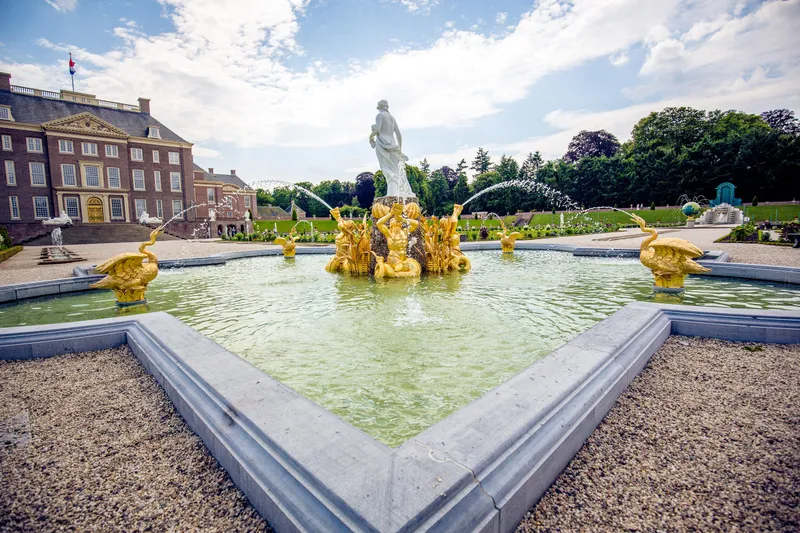 De gouden beelden in een fontein in de paleistuin