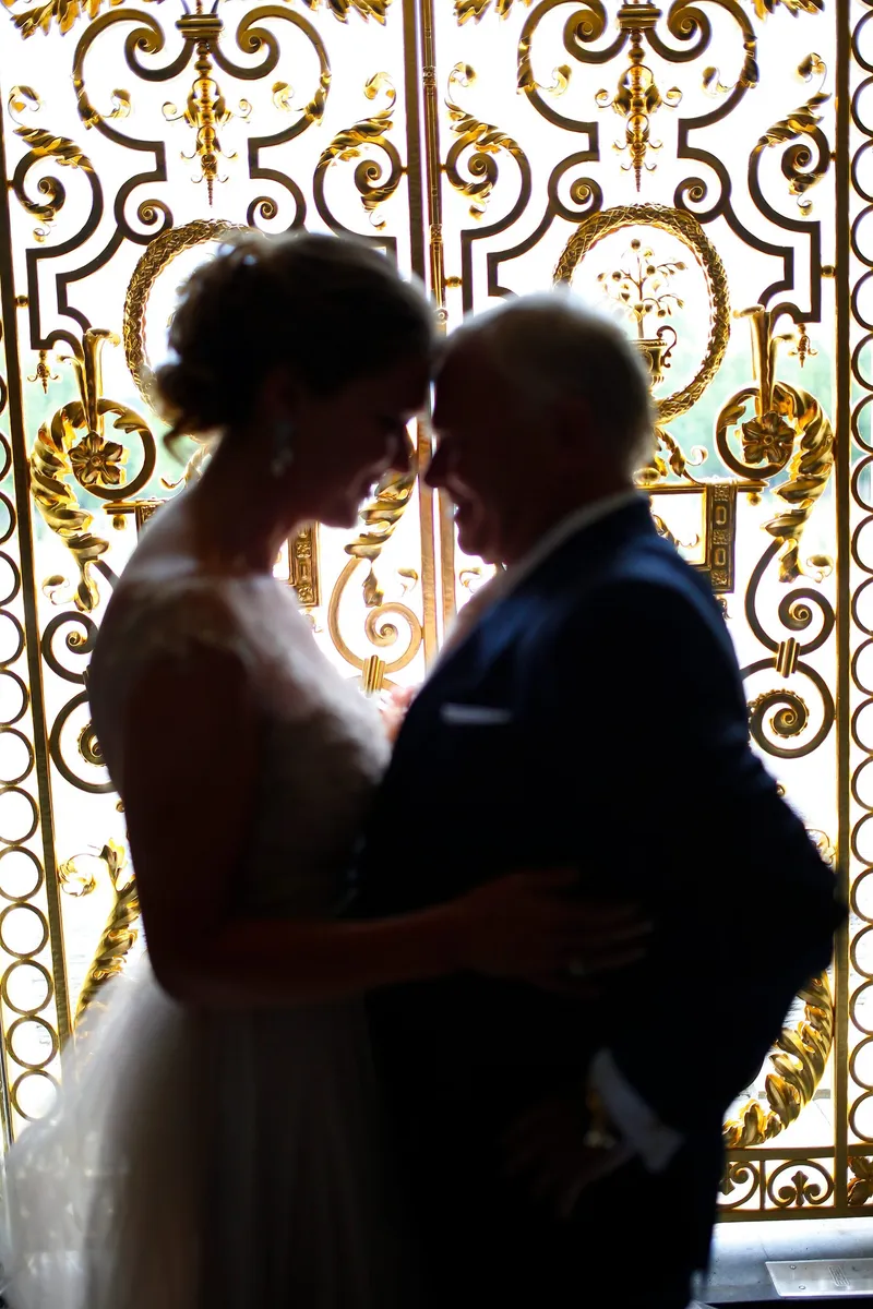 Willem en Jaqueline als silhouet tegen een gouden hek