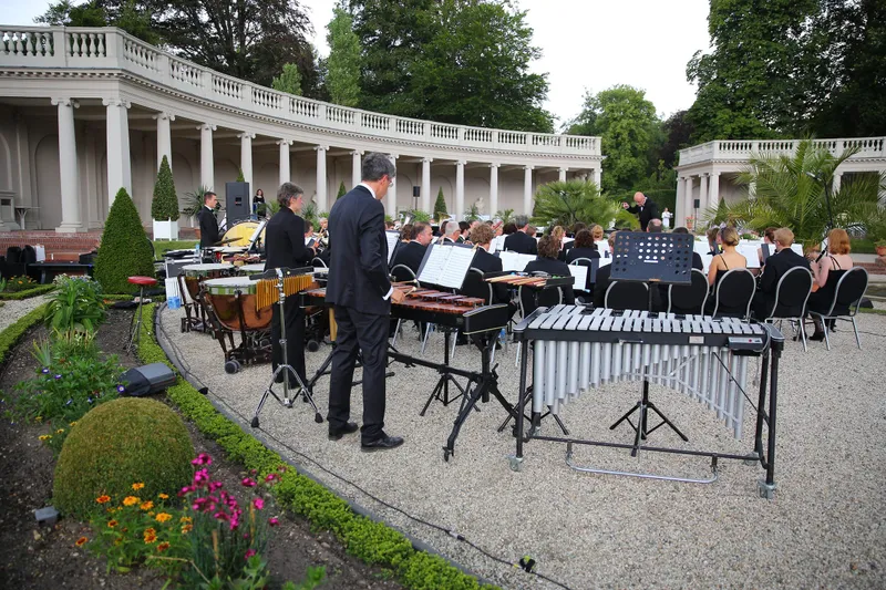 Het orkest in de tuin, met de zuilengalerij erachter